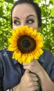Woman holding sunflower to her face Royalty Free Stock Photo