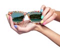 Woman is holding sunglasses with sea beach reflection o