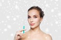 Woman holding syringe with injection over snow Royalty Free Stock Photo