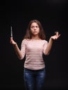 Woman holding a syringe and tuft of hair on a black background. Addiction and sickness symptoms. Hair treatment concept.