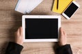 Woman holding tablet with blank screen on wooden background, top view Royalty Free Stock Photo