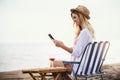 Woman holding tablet computer sitting on the beach Royalty Free Stock Photo