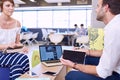 Woman holding tablet while paying attention to male business partner