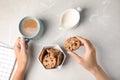 Woman holding tasty chocolate chip cookie and cup of coffee on light background Royalty Free Stock Photo