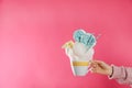 Woman holding tasty cotton candy dessert on pink background, closeup