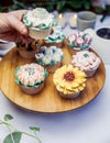 Woman holding a tasty fresh cupcake decorated with flower icing on beautiful wedding party table, high tea,Mothers day Royalty Free Stock Photo