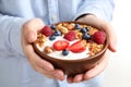 Woman holding tasty homemade granola with yogurt and berries in bowl. Healthy breakfast Royalty Free Stock Photo