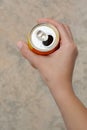 Woman holding tasty open canned beverage against blurred background, top view
