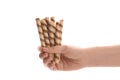 Woman holding tasty wafer roll sticks on white background, closeup. Royalty Free Stock Photo