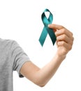 Woman holding teal awareness ribbon against white background