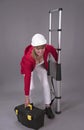 Woman holding a telescopic ladder and toolbox