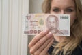 Woman holding 1000 Thai Baht note withdrawn from ATM Royalty Free Stock Photo