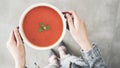 Woman holding tomato soup pot high angle view