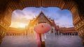 Woman holding traditional red umbrella on the Marble Temple, Wat Benchamabopitr Dusitvanaram at sunrise in Bangkok, Thailand. Royalty Free Stock Photo