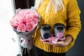 Woman holding two cups of coffee to go and a bouquet Royalty Free Stock Photo