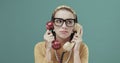 Woman holding two telephone receivers and feeling bored Royalty Free Stock Photo