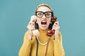 Woman holding two telephone receivers and shouting Royalty Free Stock Photo