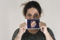 Woman holding unborn baby sonography image in hands, in front of