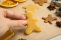 Woman holding uncooked cookie at table, closeup. Christmas biscuits