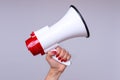Woman holding up a loud hailer or megaphone Royalty Free Stock Photo