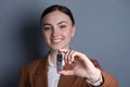 Woman holding usb flash drive on grey background, closeup Royalty Free Stock Photo