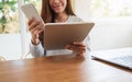 A woman holding and using mobile  phone , tablet pc and laptop computer on wooden table Royalty Free Stock Photo