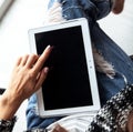 Woman holding and using tablet with empty screen