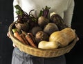 Woman holding various beetroot vegetable in wooden basket