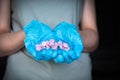 Close-up of woman wearing surgical gloves and holding pills in hands in front of torso Royalty Free Stock Photo