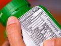 A woman holding a vitamin supplement jar with a supplement facts label Royalty Free Stock Photo