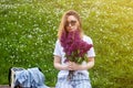 Woman holding a vivid bunch of lilac flowers against summer green floral background