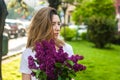 Woman holding a vivid bunch of lilac flowers in spring park