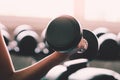 Woman holding weight to train her arm and shoulder muscles in fitness gym Royalty Free Stock Photo