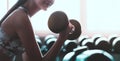 Woman holding weight to train her arm and shoulder muscles in fitness gym Royalty Free Stock Photo