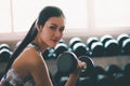 Woman holding weight to train her arm and shoulder muscles in fitness gym Royalty Free Stock Photo