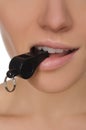 Woman holding whistle in his mouth closeup