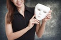 Woman holding white mask, double life