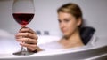 Woman holding wine glass, relaxing in cozy bathtub with foam, rest after work Royalty Free Stock Photo