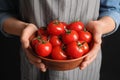 Woman holding wooden bowl with ripe cherry tomatoes Royalty Free Stock Photo