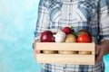 Woman holding wooden crate with vegetables on color background Royalty Free Stock Photo