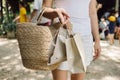 Woman holding a woven bag from Natural materials, and paper bags, shopping at local markets in Thailand, using natural renewable