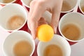 Woman holding yellow ball over cups arranged for playing beer pong, closeup Royalty Free Stock Photo