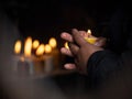 Woman holding burning candle in her hands memory grief religion faith belief in Las Lajas Sanctuary Ipiales Colombia