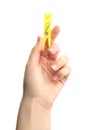 Woman holding yellow plastic clothespin on white background, closeup Royalty Free Stock Photo