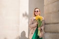 Woman holding yellow tulips, leaning against stone wall. Women& x27;s holiday concept, giving flowers. Royalty Free Stock Photo