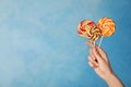 Woman holding yummy candies on color background. Royalty Free Stock Photo