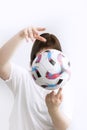 Woman holds ball in hands. Close up. Sports training with the ball. White background. Ball in hands of a football coach
