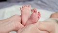 Woman holds bare feet of newborn baby making shape of heart Royalty Free Stock Photo