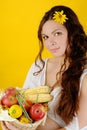 Woman holds a basket of fruit and vegetables. looking at camera Royalty Free Stock Photo