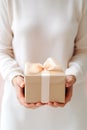 A woman holds a beautifully wrapped gift box. The focus on the gift symbolizes appreciation, thoughtfulness